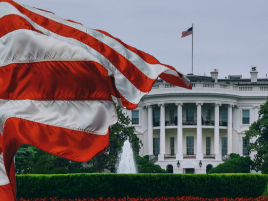 American flag waving in front of the White House